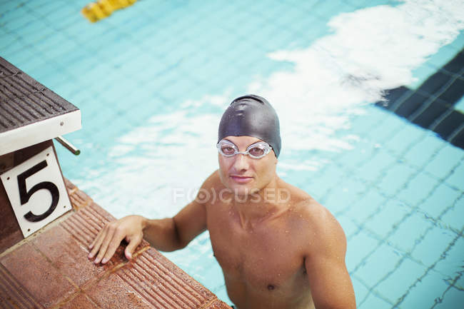 Portrait of swimmer standing at the edge of pool — Stock Photo