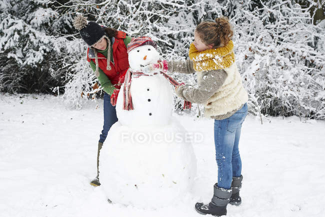 Кавказская счастливая мать и дочь делают снеговика — стоковое фото