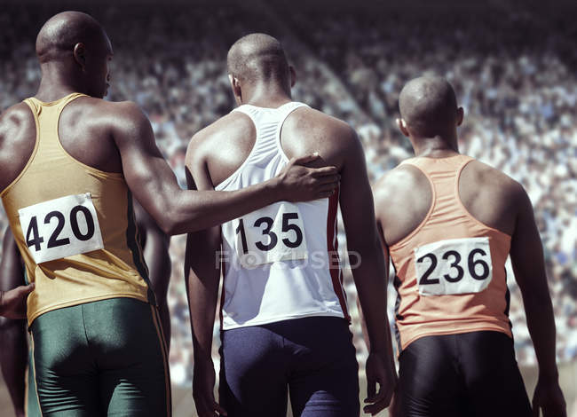 Runner comforting teammate on track — Stock Photo
