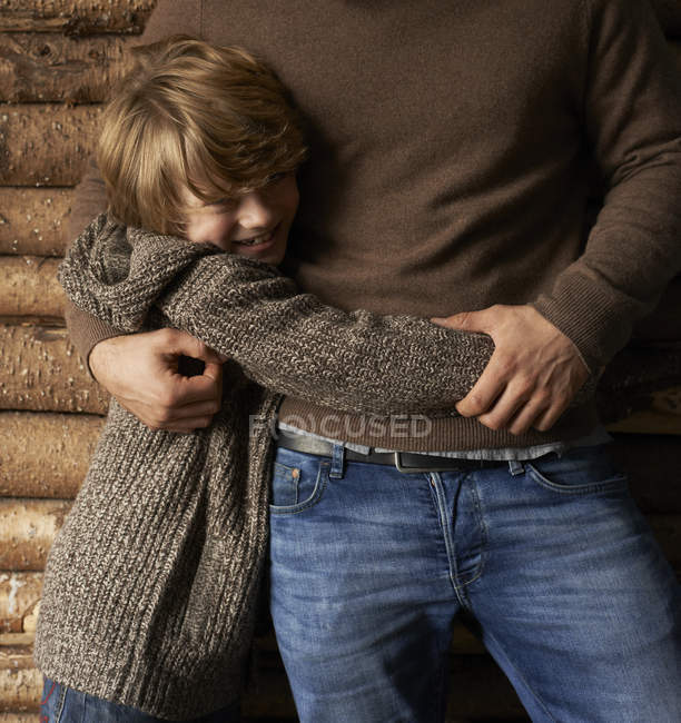 Усміхнений син обіймає батька, крупним планом — стокове фото