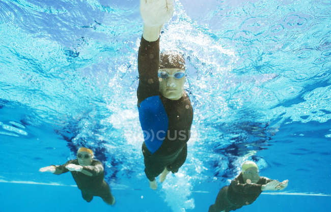 Впевнені і сильні тріатлоністи в костюмах під водою — стокове фото