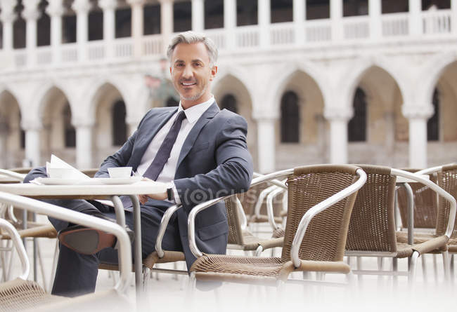 Portrait of smiling businessman at sidewalk cafe in Venice — Stock Photo