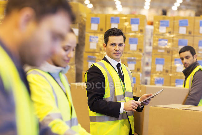 Empresario y trabajadores en almacén - foto de stock