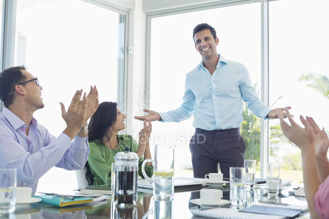Gente de negocios animando en la reunión en la oficina moderna - foto de stock