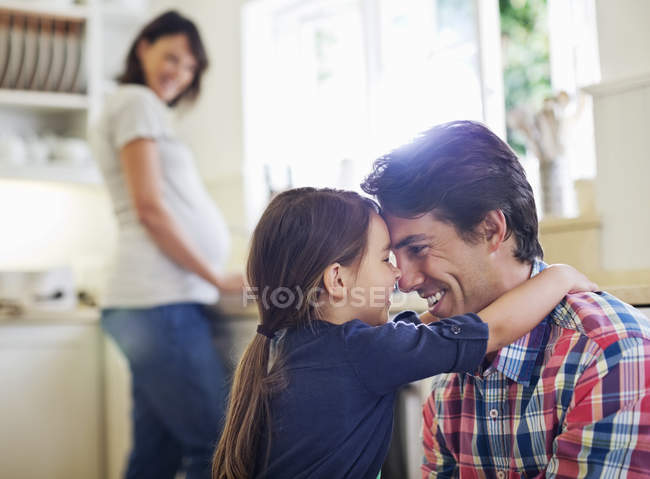 Padre e hija abrazándose en la cocina - foto de stock