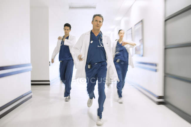 Medici che corrono lungo il corridoio dell'ospedale — Foto stock