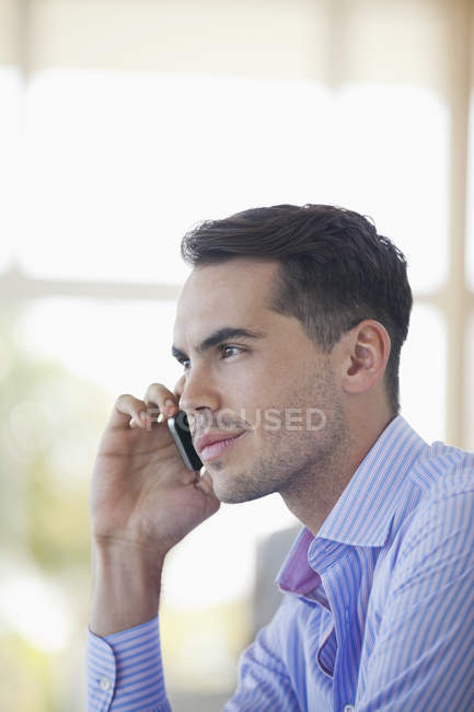 Бізнесмен розмовляє по мобільному телефону в сучасному офісі — стокове фото