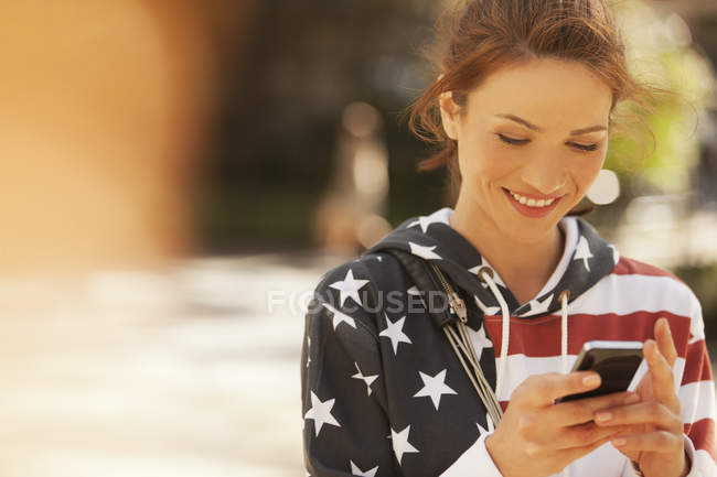 Woman using cell phone on city street — Stock Photo