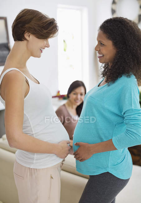Беременные женщины касаются живота — стоковое фото