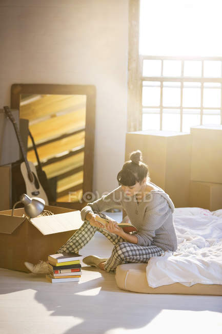 Mujer desembalaje caja en nuevo hogar - foto de stock