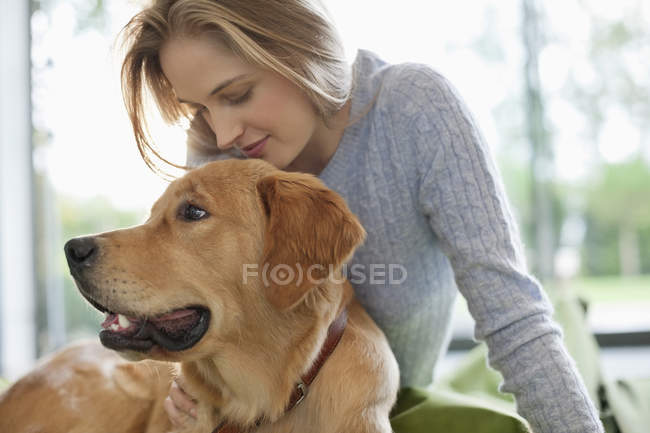Mujer relajante con perro en casa moderna - foto de stock