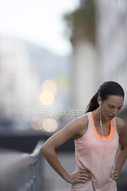Жінка відпочиває після бігу на міській вулиці — стокове фото