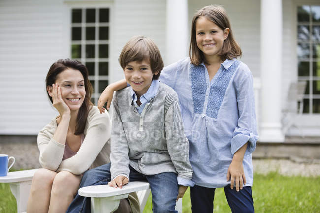 Mother and children smiling outdoors — Stock Photo