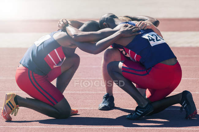 Runners huddled on track during daytime — Stock Photo