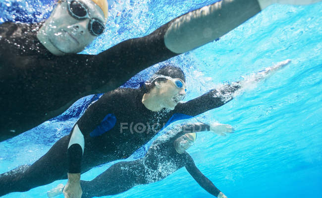 Впевнені і сильні тріатлоністи в костюмах під водою — стокове фото