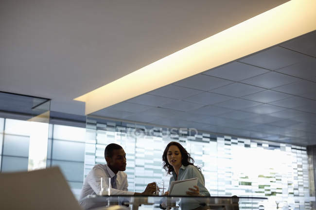 Homme d'affaires et femme d'affaires discutant de paperasserie au bureau moderne — Photo de stock