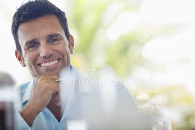 Empresario sonriendo en el escritorio en la oficina moderna - foto de stock