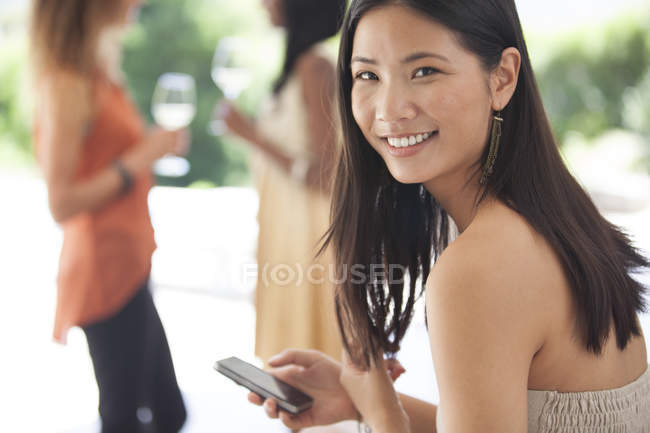 Молода приваблива усміхнена жінка використовує мобільний телефон — стокове фото