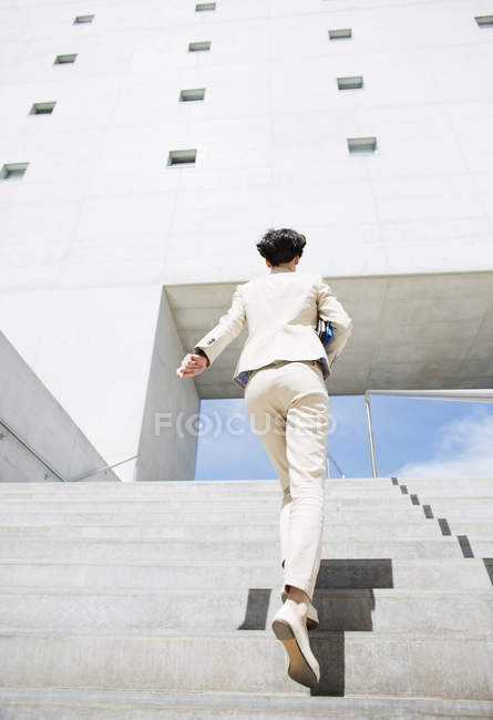 Empresária correndo escadas urbanas — Fotografia de Stock