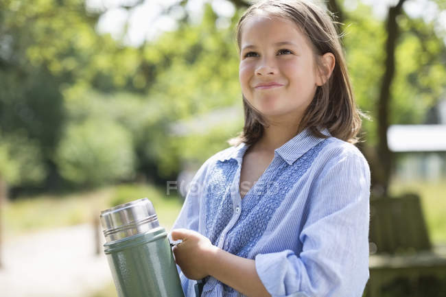 Mädchen trägt Thermoskanne im Freien — Stockfoto