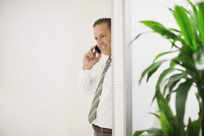 Uomo d'affari che parla al cellulare in ufficio moderno — Foto stock