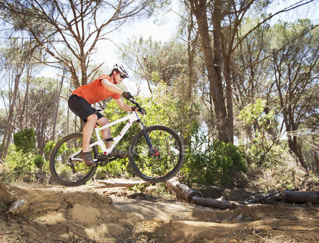 Side view of mountain biker on dirt path at forest — Stock Photo