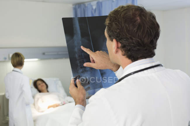 Доктор вивчає рентгенівські промені в лікарняній кімнаті — стокове фото