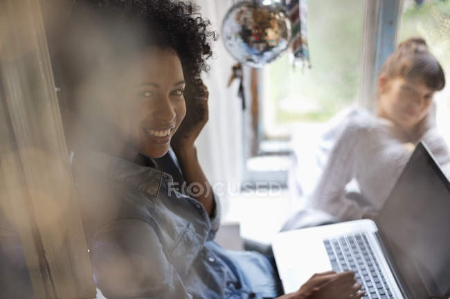 Jovem mulher feliz usando laptop na janela — Fotografia de Stock