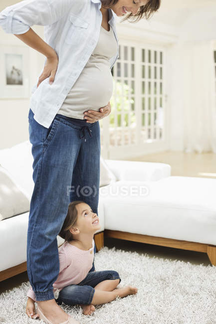 Дівчина тримає ноги вагітних матерів — стокове фото