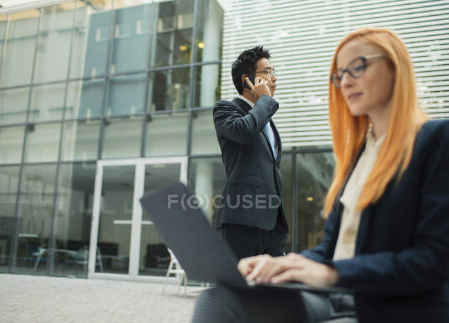 Geschäftsleute arbeiten außerhalb des Bürogebäudes — Stockfoto