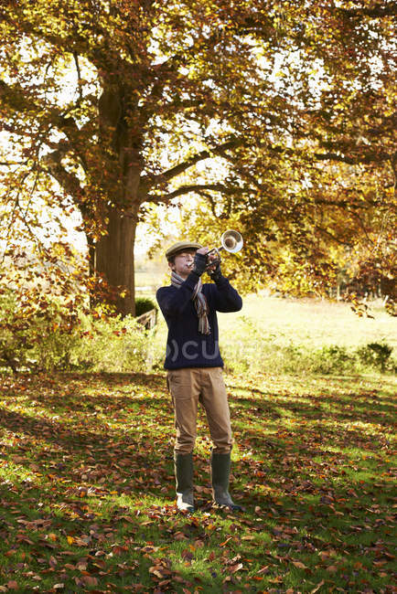 Мальчик-подросток играет на трубе на открытом воздухе — стоковое фото