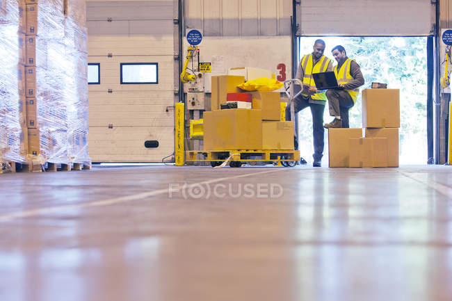 Рабочие проверяют коробки на складе — стоковое фото