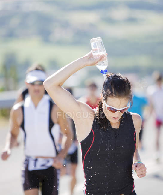 Runner versando acqua sulla testa in gara — Foto stock