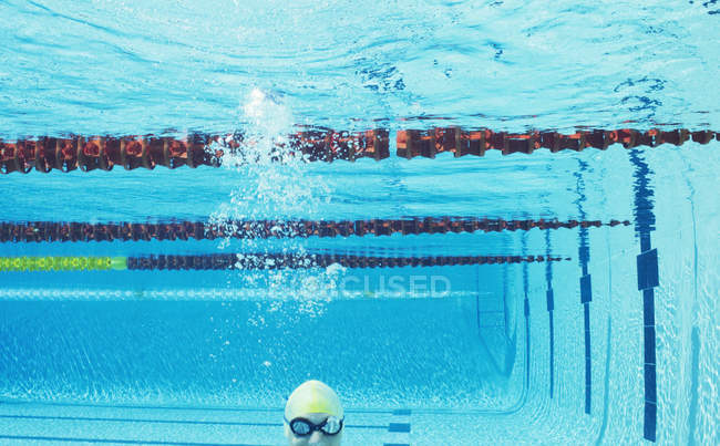 Swimmer smiling underwater in swimming pool — Stock Photo