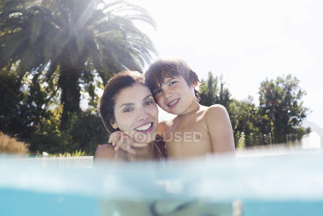 Mãe segurando filho na piscina — Fotografia de Stock
