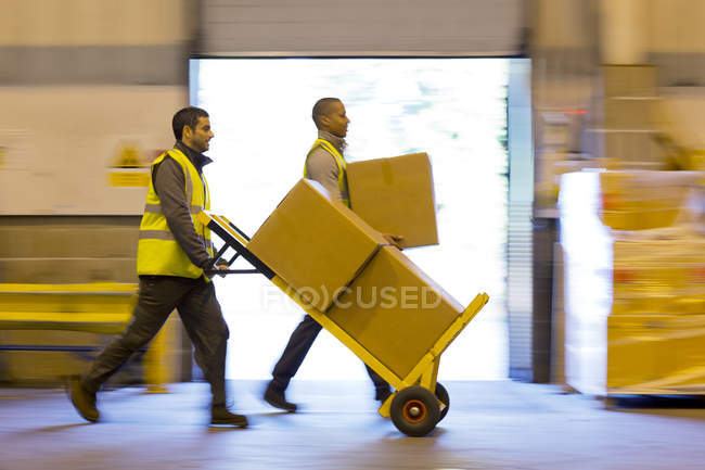 Travailleurs chariots boîtes dans l'entrepôt — Photo de stock