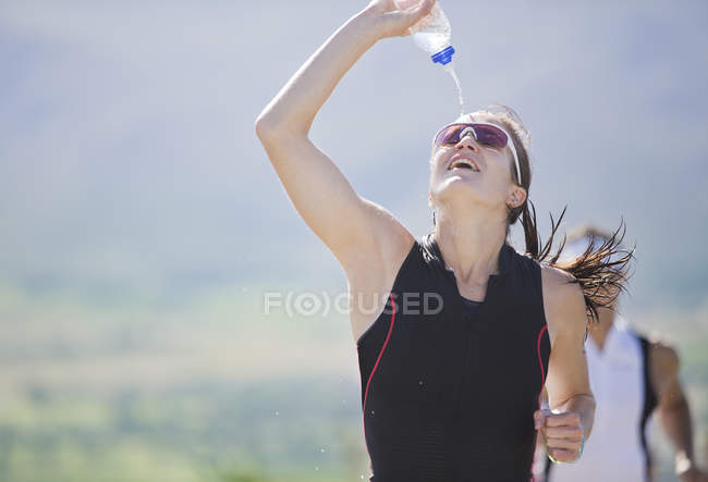 Runner spraying water in race — Stock Photo
