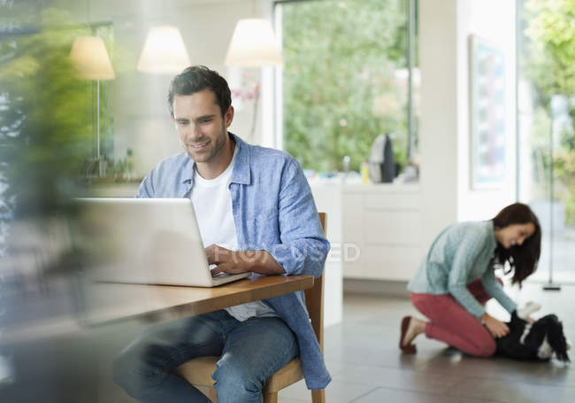 Man using laptop in kitchen at modern home — Stock Photo