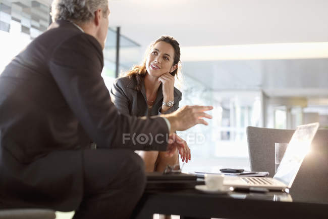 Uomo d'affari e donna d'affari che parlano nella hall dell'ufficio moderno — Foto stock