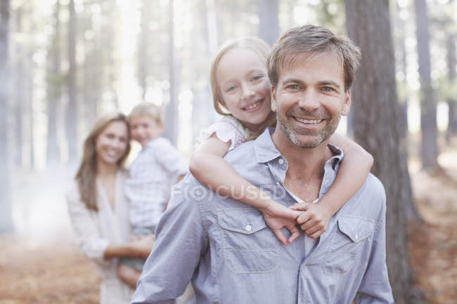 Retrato de familia sonriente en el bosque - foto de stock