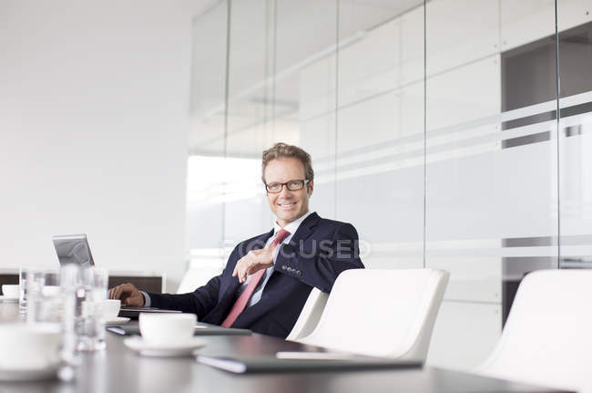 Geschäftsmann sitzt in modernem Büro am Besprechungstisch — Stockfoto