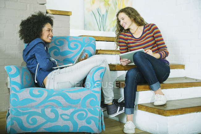 Junge Frauen entspannen gemeinsam auf Stufen — Stockfoto