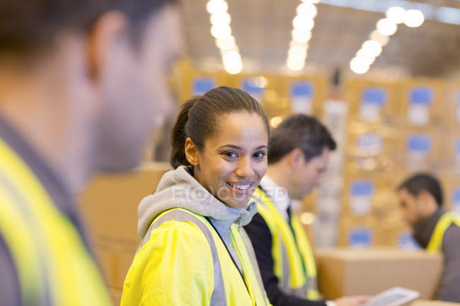 Trabalhador sorrindo no armazém — Fotografia de Stock