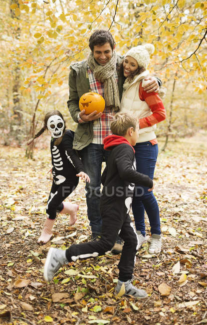 Paar mit Kindern in Skelettkostümen im Park — Stockfoto