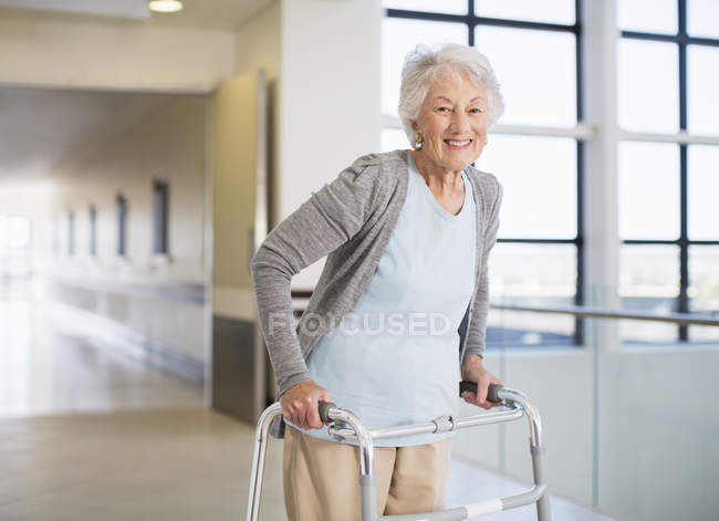 Paciente mayor que usa andador en el hospital - foto de stock