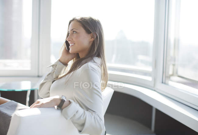 Businesswoman talking on phone at modern office — Stock Photo