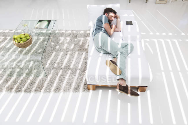 Mann schläft auf Liege in modernem Wohnzimmer — Stockfoto
