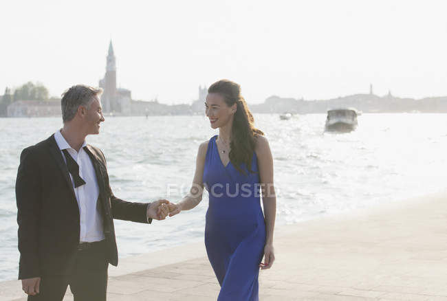 Gut gekleidetes Paar Händchen haltend am Wasser in Venedig — Stockfoto