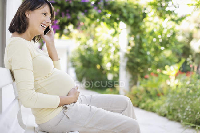 Mulher grávida falando no telefone celular — Fotografia de Stock