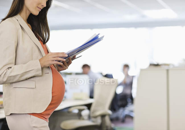 Embarazada mujer de negocios trabajando en la oficina - foto de stock